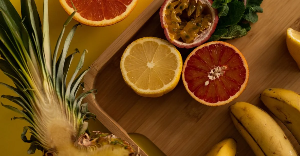 Une sélection vibrante de fruits tropicaux frais sur une planche en bois, capturée par le haut.
