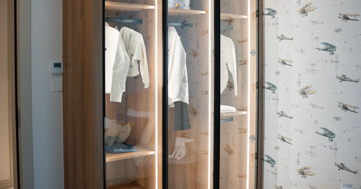 Armoire en bois avec portes en verre dans un intérieur moderne, mettant en valeur le style de mode minimaliste.