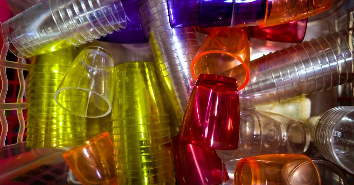 Une vue vibrante d'en haut de divers gobelets en plastique colorés empilés, idéal pour des soirées.