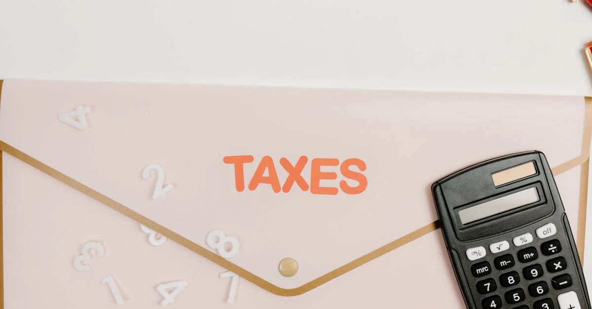 Plan rapproché d'une calculatrice et d'un dossier étiqueté 'Taxes' pour la finance et la comptabilité.