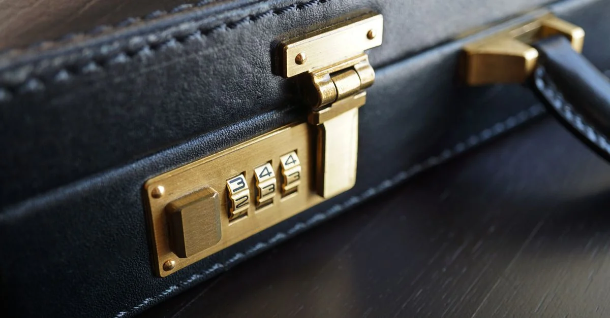 Gros plan sur une mallette en cuir noir avec une serrure à combinaison en laiton pour la sécurité des affaires.