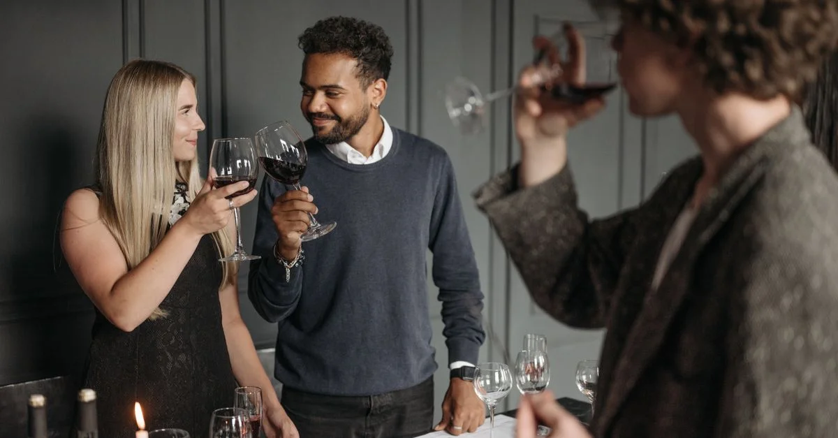 Des adultes profitant d'un événement de dégustation de vin élégant, portant un toast avec des verres à l'intérieur.